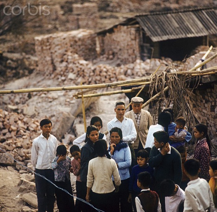 Một nhóm người đứng trên đống đổ nát của một ngôi nhà trong khu phố Khâm Thiên sau vụ tấn công của Mỹ năm 1972. Ảnh chụp năm 1973. Nguồn: Corbis.
